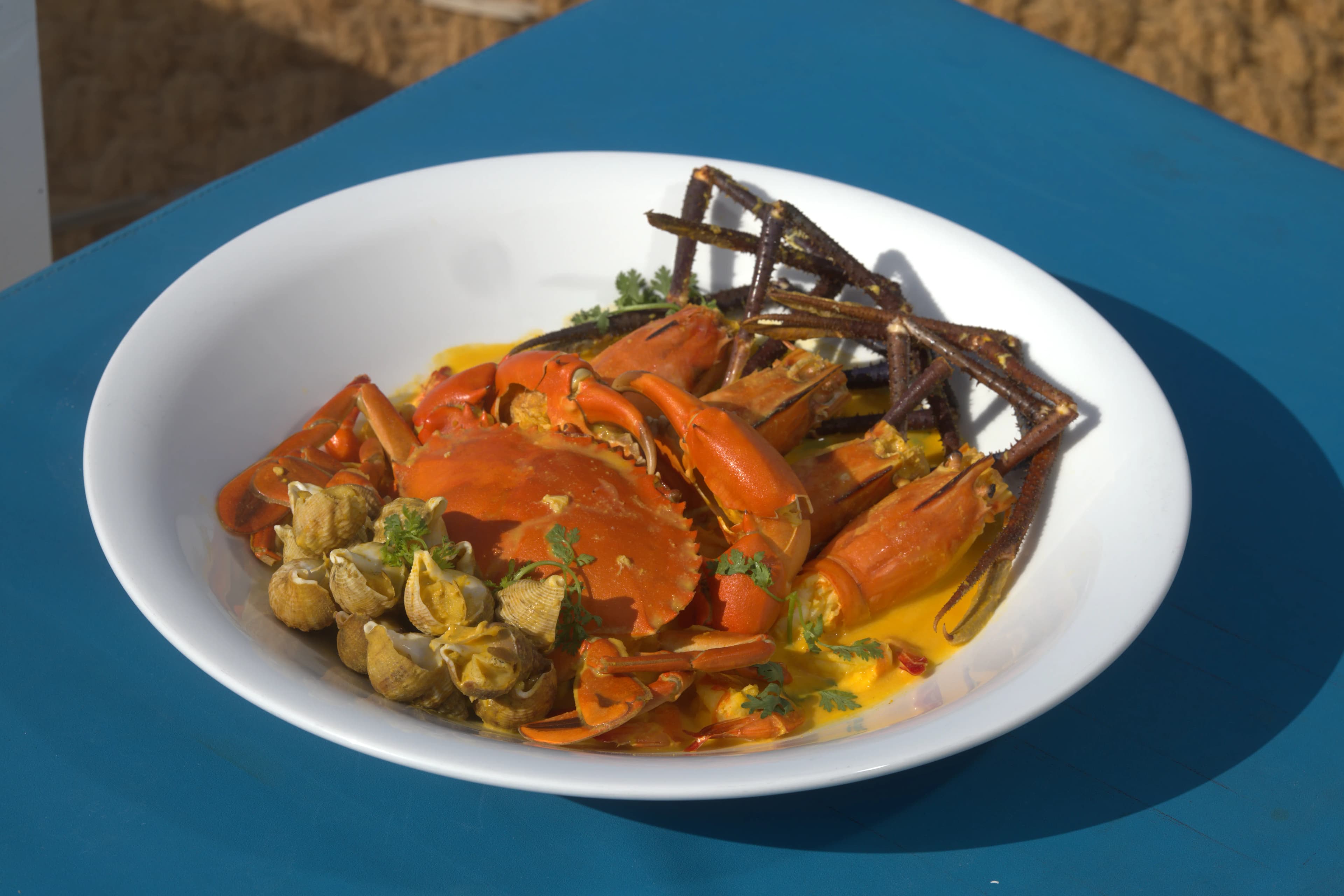Golden seafood bowl with crab, whelks, river shrimp, and salted egg sauce
